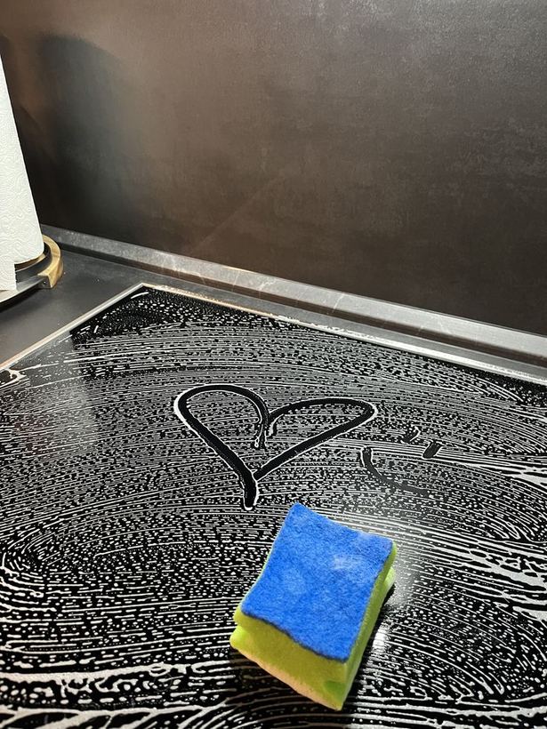 A heart drawn in the suds on a freshly wiped stovetop